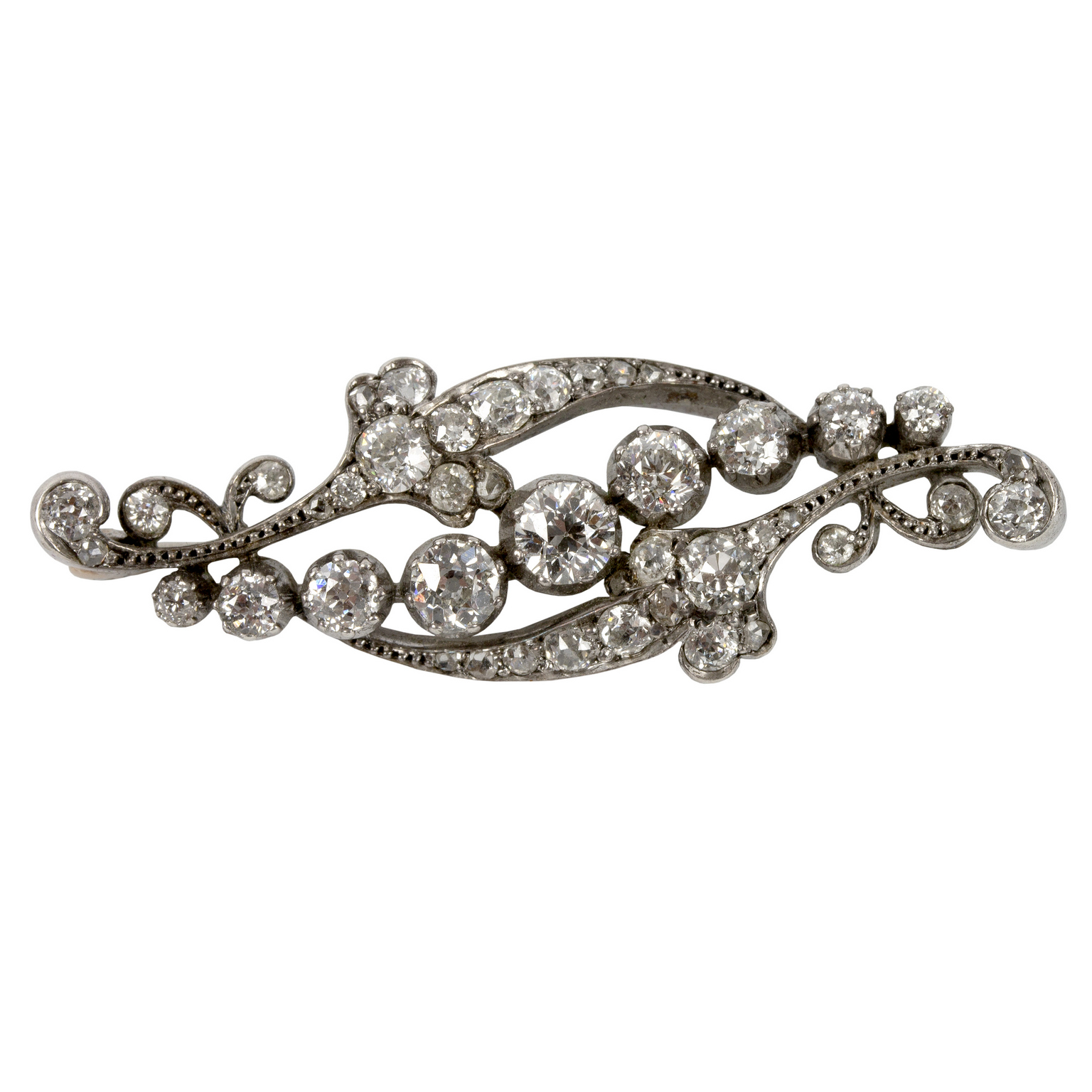 A diamond brooch of scrolling form,