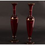 A pair of red glass vases of baluster form,