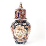 A Japanese Imari vase and cover of reeded form, painted reserves of garden landscapes,