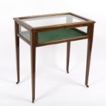 An Edwardian mahogany display case with parcel gilt borders on square taper legs,
