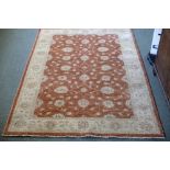 A modern Ziegler design rug with foliate designs to an apricot ground, within an oatmeal border,