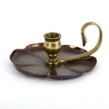 An Arts and Crafts style copper candle holder shaped as stylised flowerhead, with brass handle,