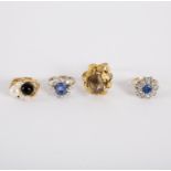 A dress ring of flowerhead cluster form with central blue stone and surround of white stones