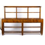 A 1930s walnut dresser, the rack fitted two shelves divided into four sections,