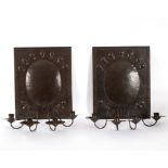 A pair of Arts & Crafts style four-branch wall lights on panel backs,