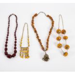 A single row of graduated cherry amber beads and sundry amber and faux amber necklaces