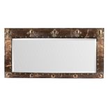 A Newlyn School copper wall mirror, the hammered frame embossed a row of fleurs-de-lys to the top,