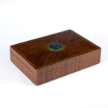 A wooden cigarette box, the quarter veneered hinged lid with applied circular enamel motif WHS,