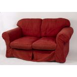 A modern two-seater sofa with loose covers in textured claret cloth,