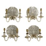 Manner of the Cotswold School, a set of four Arts & Crafts style metal wall lights,