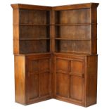 A Cotswold School oak corner bookcase, the top with two shelves,
