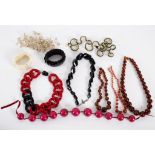 A 1980s black and red flat link necklace, a black facetted necklace, three amber coloured necklaces,
