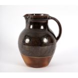 Winchcombe Pottery, a baluster jug, tenmoku glazed with band of combed wave decoration, 20cm high,