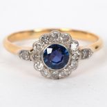 A sapphire and diamond cluster ring flanked by a diamond to each shoulder,