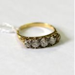 An Edwardian five-stone diamond ring, the graduated stones in a yellow gold scroll setting,