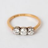 A diamond three-stone ring, the stones set in platinum to an 18ct yellow gold shank,