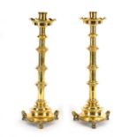 A pair of 19th Century Gothic brass candlesticks with ringed stems on three lion feet,