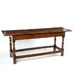 An oak serving table with two-plank top on baluster turned legs united by square stretchers,
