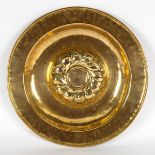 A Nuremberg brass alms dish with embossed centre and inscription,