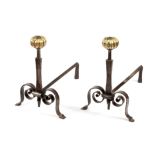 A pair of wrought iron fire dogs with reeded ball finials,