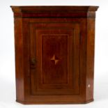 An oak corner cupboard, the panelled door inlaid a diaper,