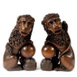 A pair of Renaissance style carved oak seated lions, stained and part painted features,