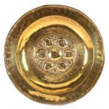 A Nuremberg brass alms dish with embossed centre and inscription,