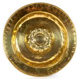 A Nuremberg brass alms dish with embossed centre and inscription, 46.