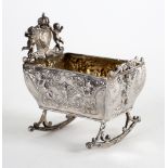 A Dutch silver toy cradle, Chester import marks 1912, embossed musical putti, 8cm wide,