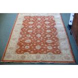 A modern Ziegler design rug with foliate designs to an apricot ground, within an oatmeal border,