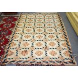 A European needlepoint rug, early 20th Century, the coffered field with rosettes,