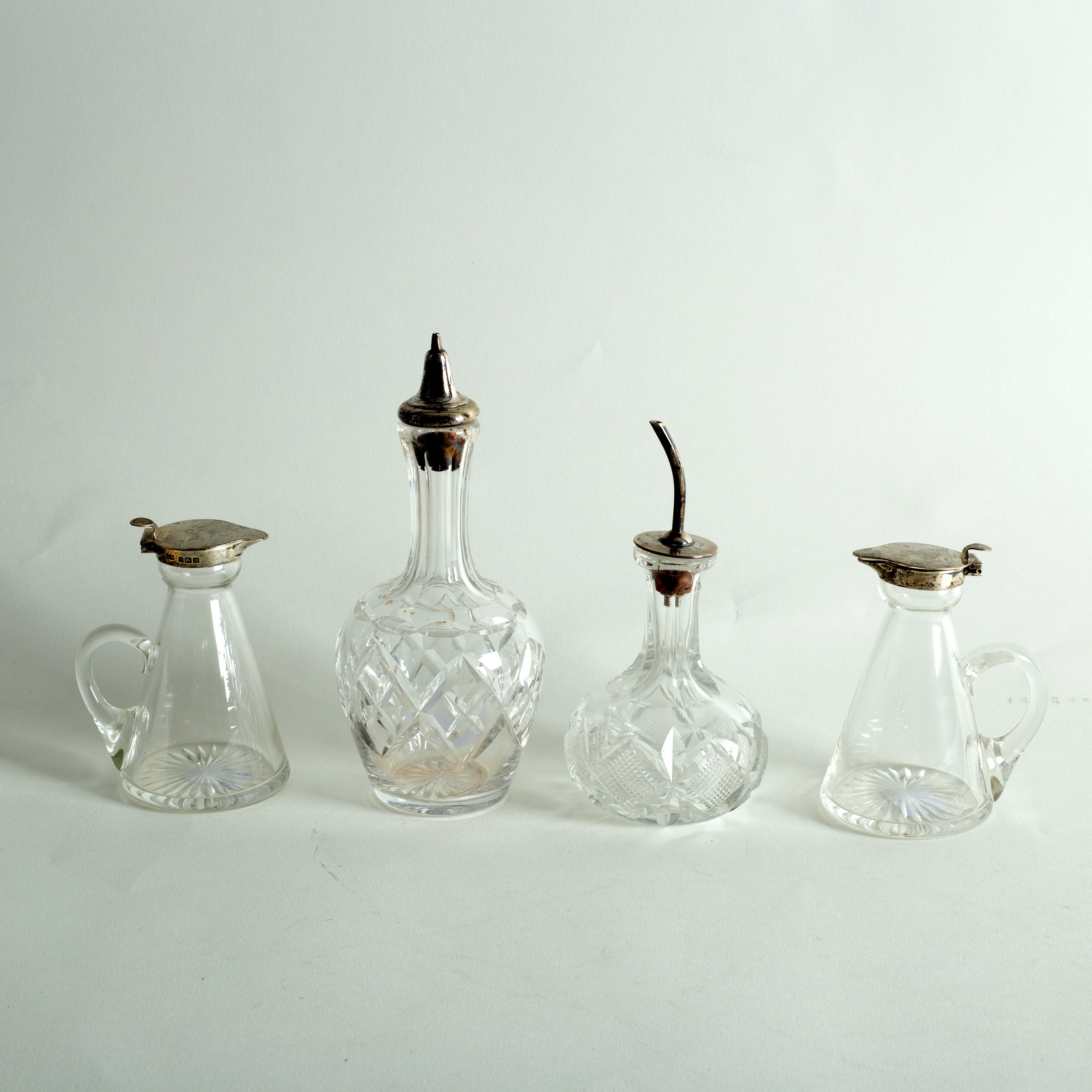 A pair of cruet bottles with silver mounts, H & H Birmingham 1928 and two others,