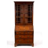 A George III mahogany bureau bookcase, with glazed upper section and later inlays to the fall,