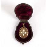 A Victorian oval locket decorated a cross in diamonds and childrens teeth, to a blue enamel border,