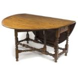 An 18th Century oak two-flap table, on bobbin turned legs and stretchers,