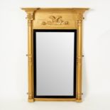 A Regency giltwood wall mirror with eagle surmount, the plate flanked by columns,