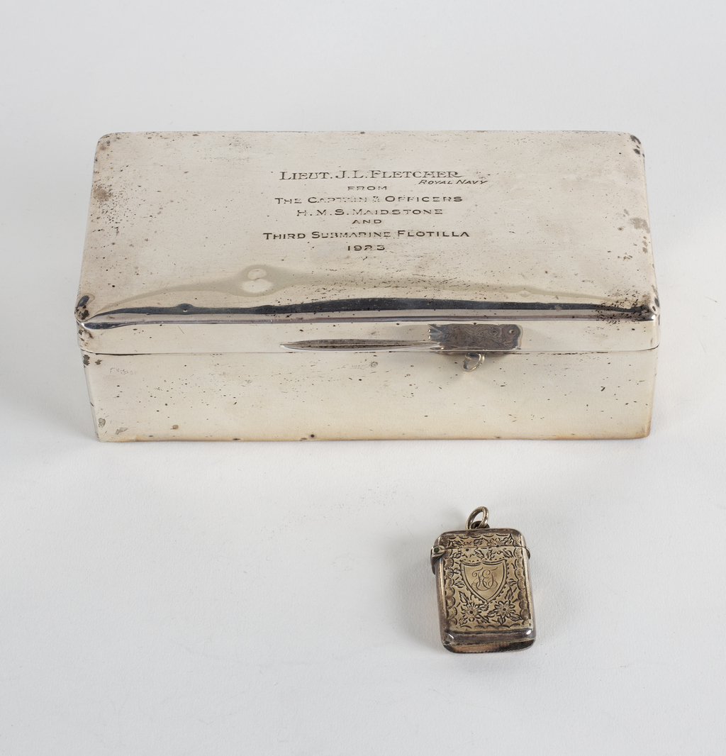 A silver cigarette box, marks rubbed, inscribed to Lieut.