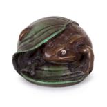 A 20th Century Russian resin paperweight modelled as a frog sheltering beneath a leaf,