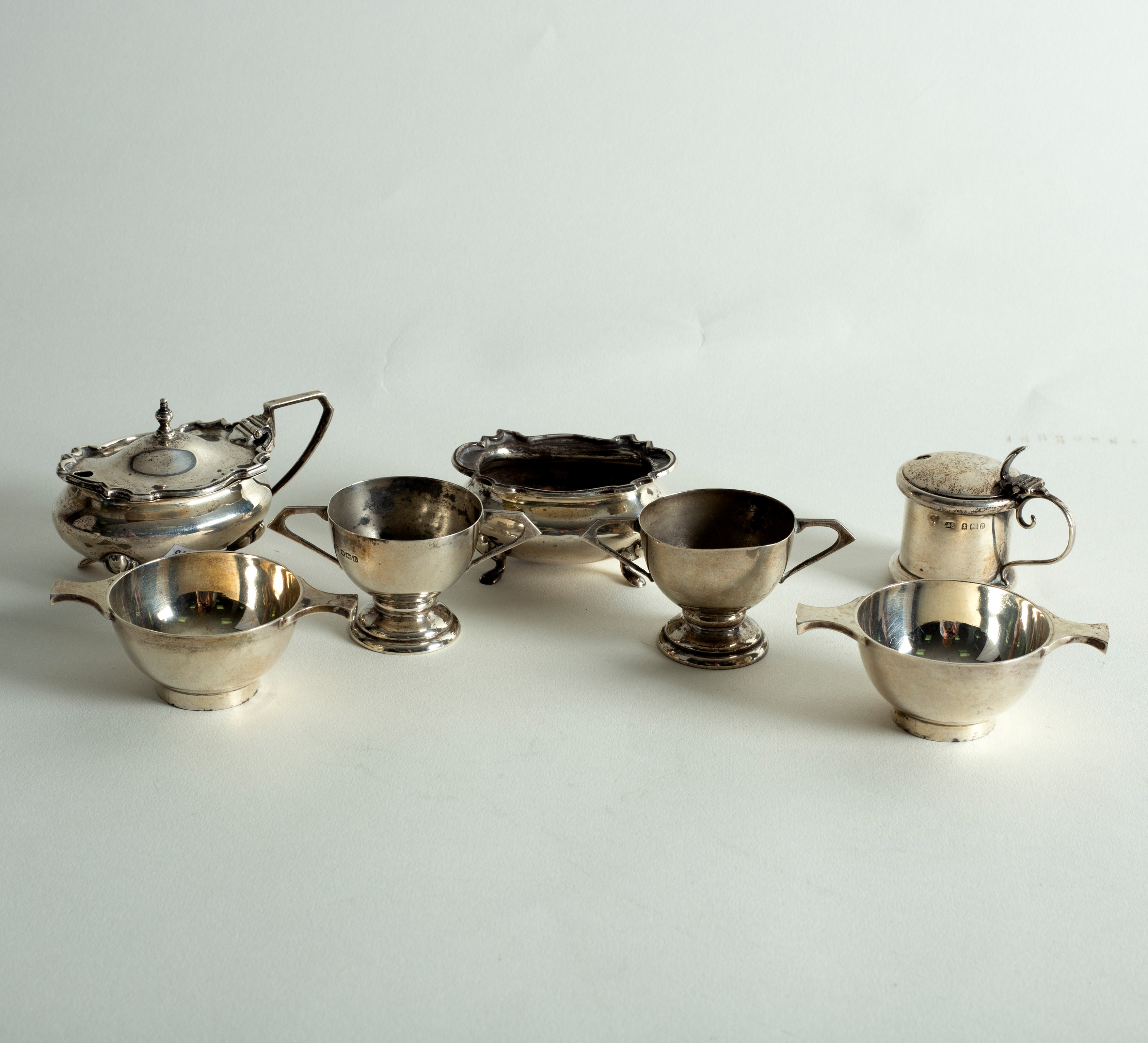 A pair of silver salts of miniature porringer form, two small trophy cups,