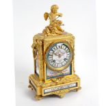 A gilt metal mounted eight-day mantel clock with porcelain mounts,