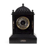 A black slate mantel clock the silvered dial with Roman numerals,