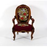 A Victorian open armchair, the walnut frame carved fruit and flowers, with tapestry seat,