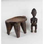 A tribal stool with concave seat on tapering supports, 43cm wide and a carved tribal figure,