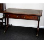 A Victorian writing table with tooled leather top above two drawers and on end supports,