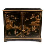 A chinoiserie decorated side cabinet in gilt and green lacquer enclosed by a pair of doors,