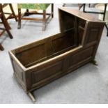 A plain 18th Century oak cradle with panelled sides and ends,