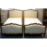 A pair of French single beds, each oak framed with upholstered head and foot,