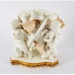 A Moore porcelain centrepiece modelled as a flowerhead on three cherub supports,