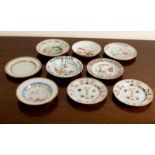 Nine 18th Century dishes comprising a pair of Imari plates painted with antiques,