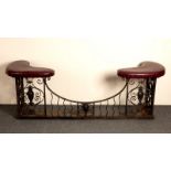 A wrought iron club fender with down swept central section and upholstered kidney shaped seats to